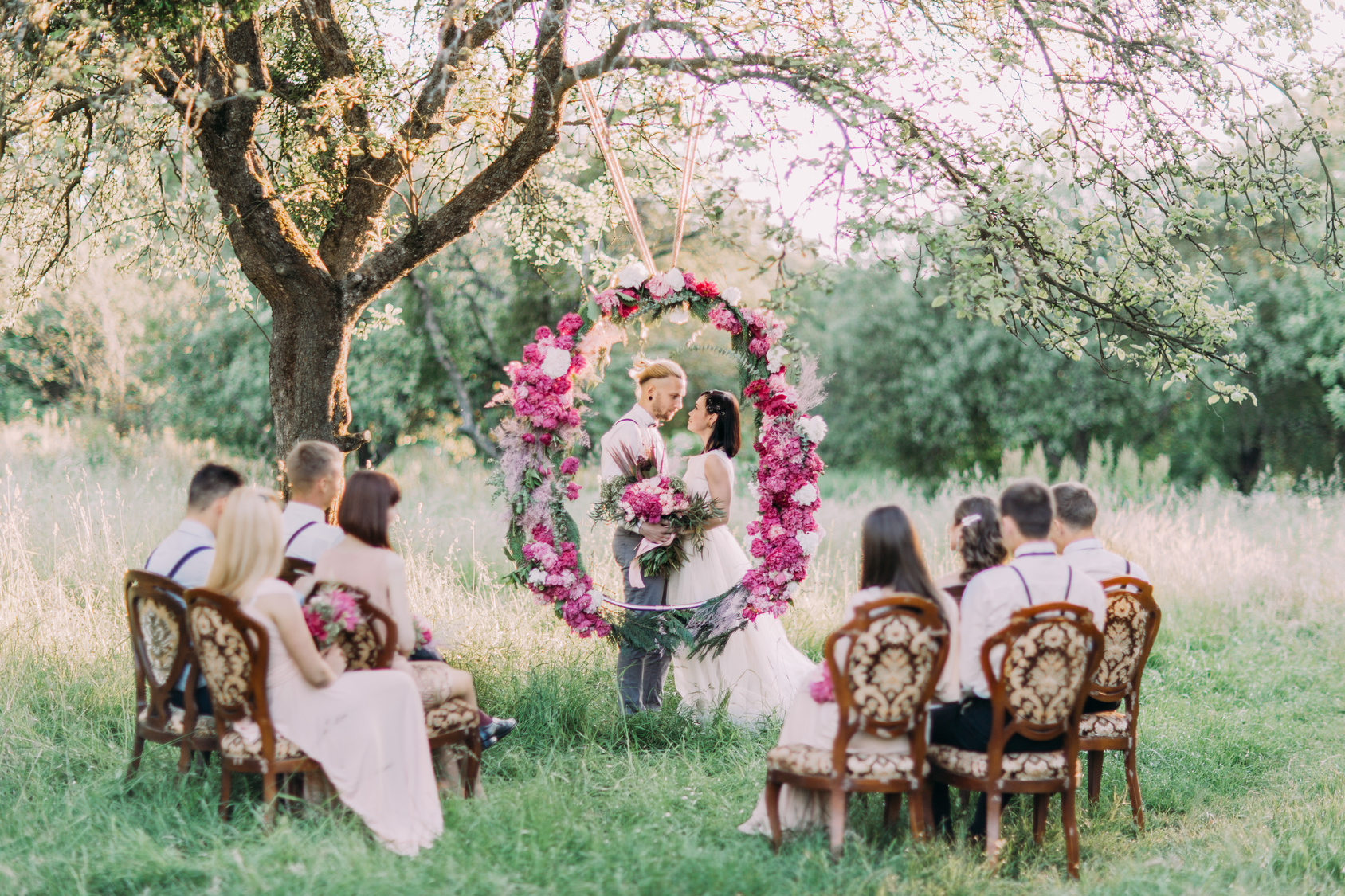 The beautiful wedding ceremony in the sunny park. The horizontal photo